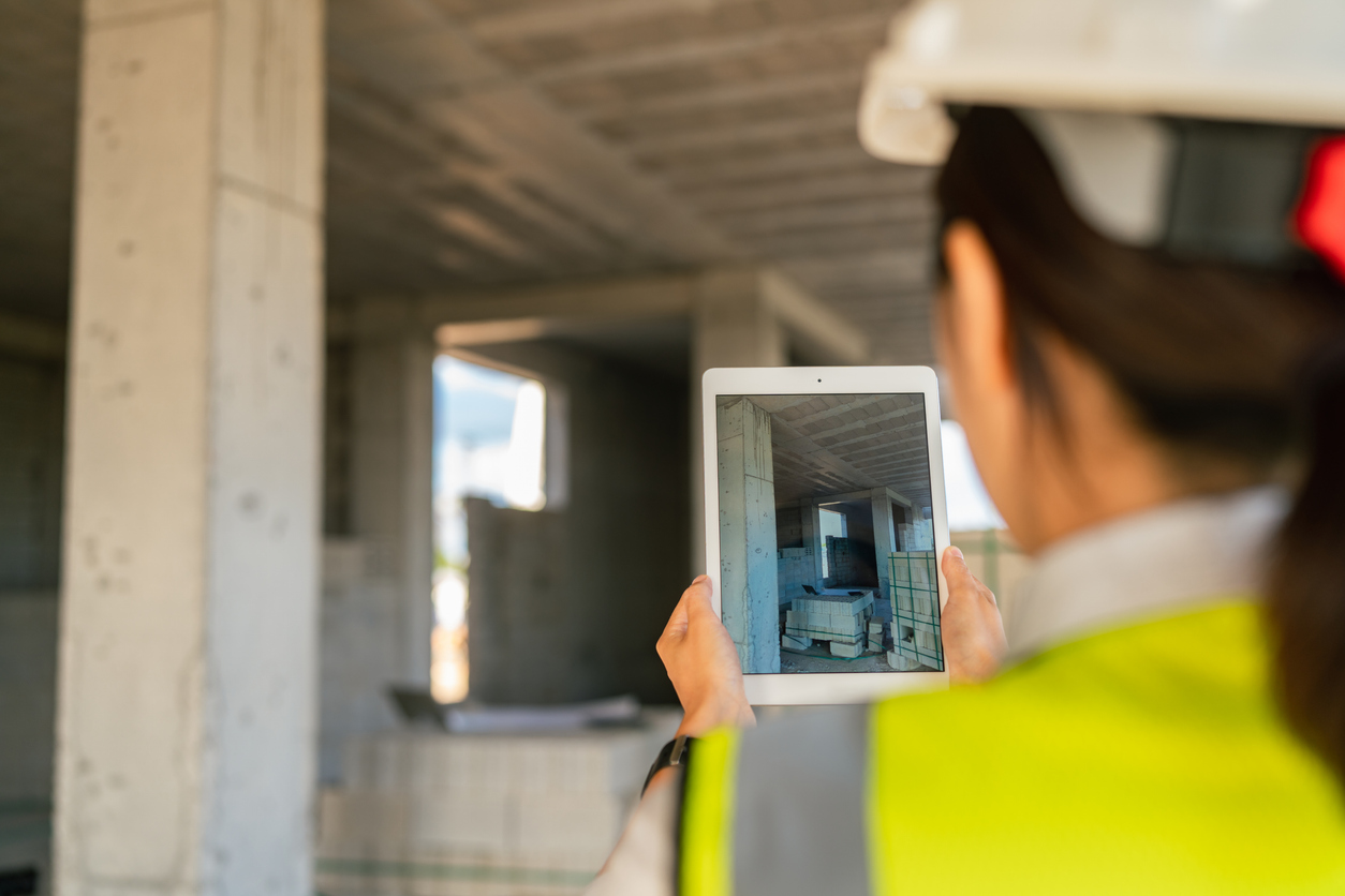 Bauingenieurin erfasst die Lage der Baustelle mit dem Tablet.